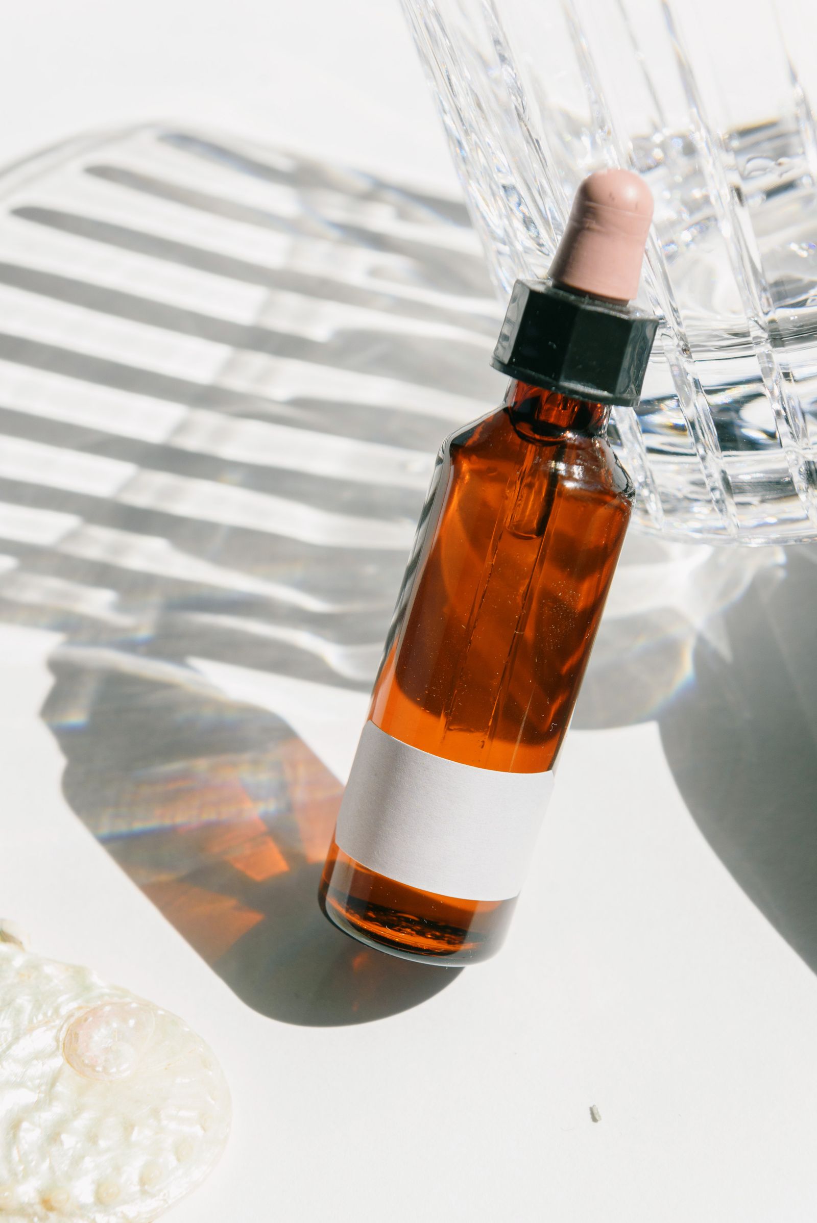 Frasco conta-gotas de ativo de skincare sobre fundo neutro